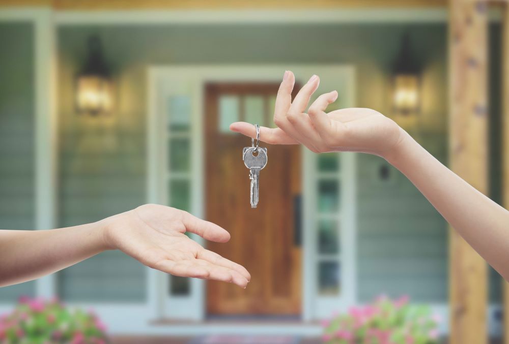 Keys to a new home dangling from someone's finger